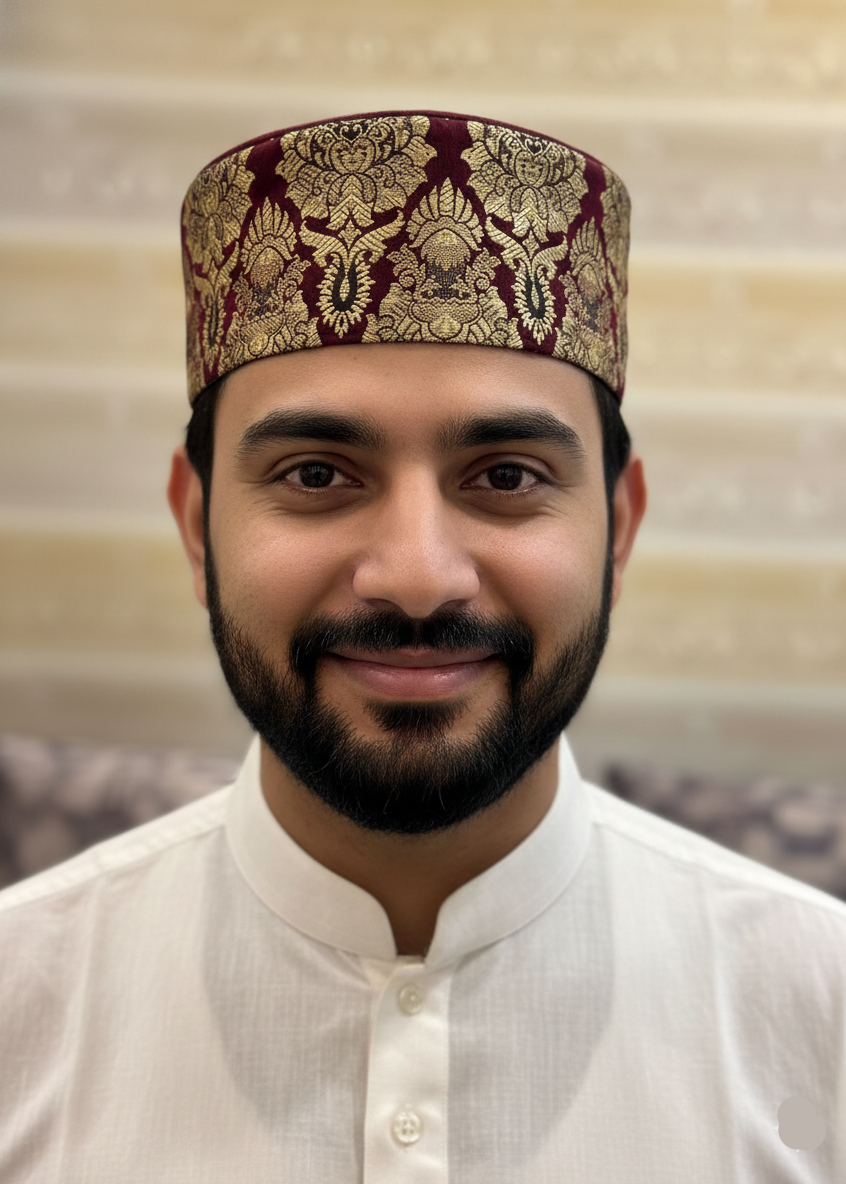 Man wearing a traditional embroidered cap and white outfit against a neutral background